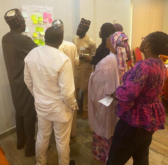 Group of people around a sticky note board